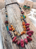Amber and cranberry orange beaded necklace with multicolored gemstone beads and metal accents, handmade by Melly
