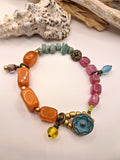 Amber and wine red beaded charm bracelet with a blue button closure, handmade by Melly