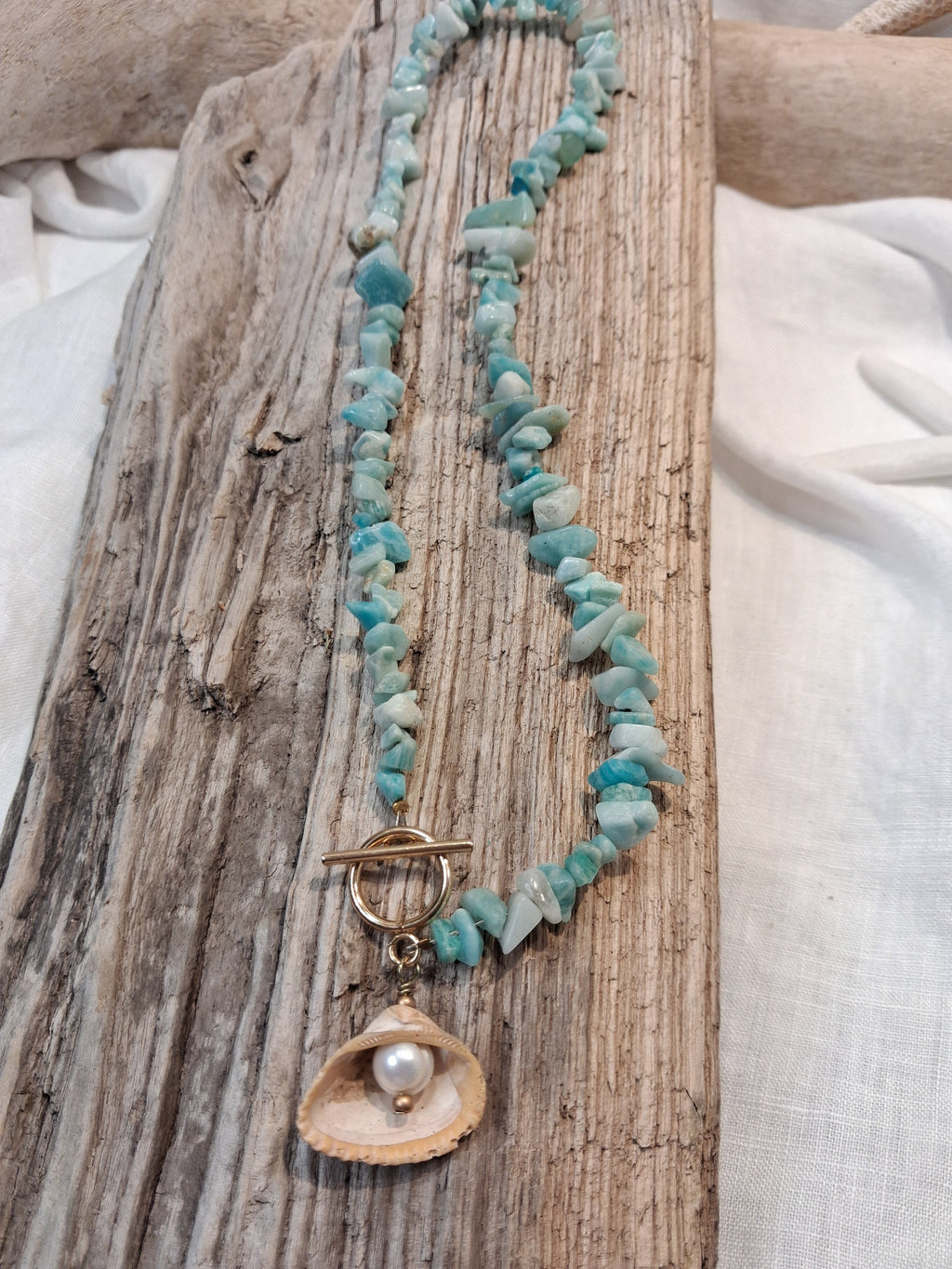 Blue aquamarine beaded chip necklace featuring a mother of pearl shell pendant, handmade by Melly