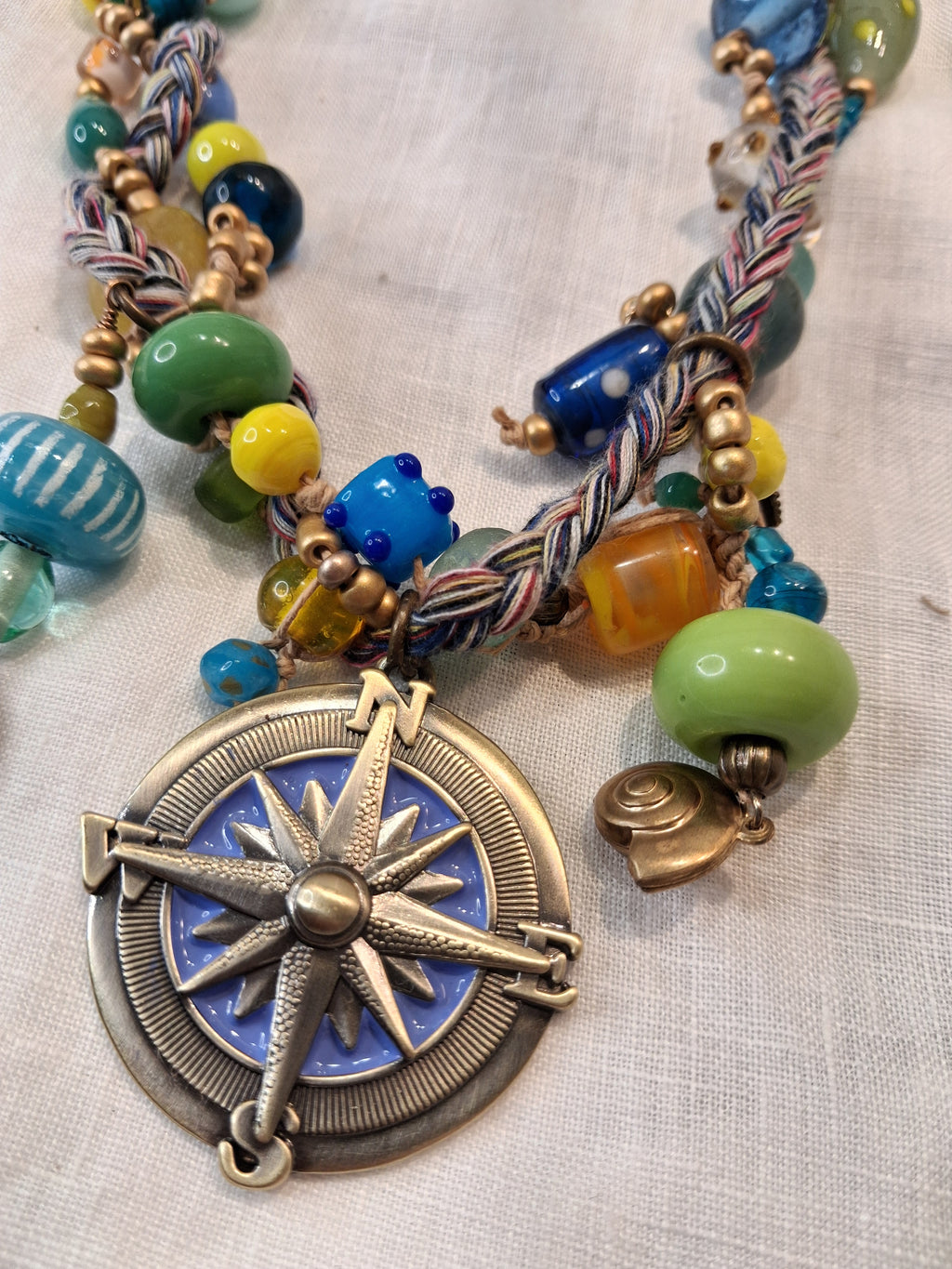 Multi-color glass bead and braided cord necklace with gold metal accents, handmade by Melly
