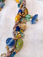 Multicolor glass beads and braided cord statement necklace with a brass compass pendant, handmade by Melly