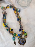 Cobalt, teal, and yellow beaded Nautica necklace with glass beads and a compass pendant, handmade by Melly