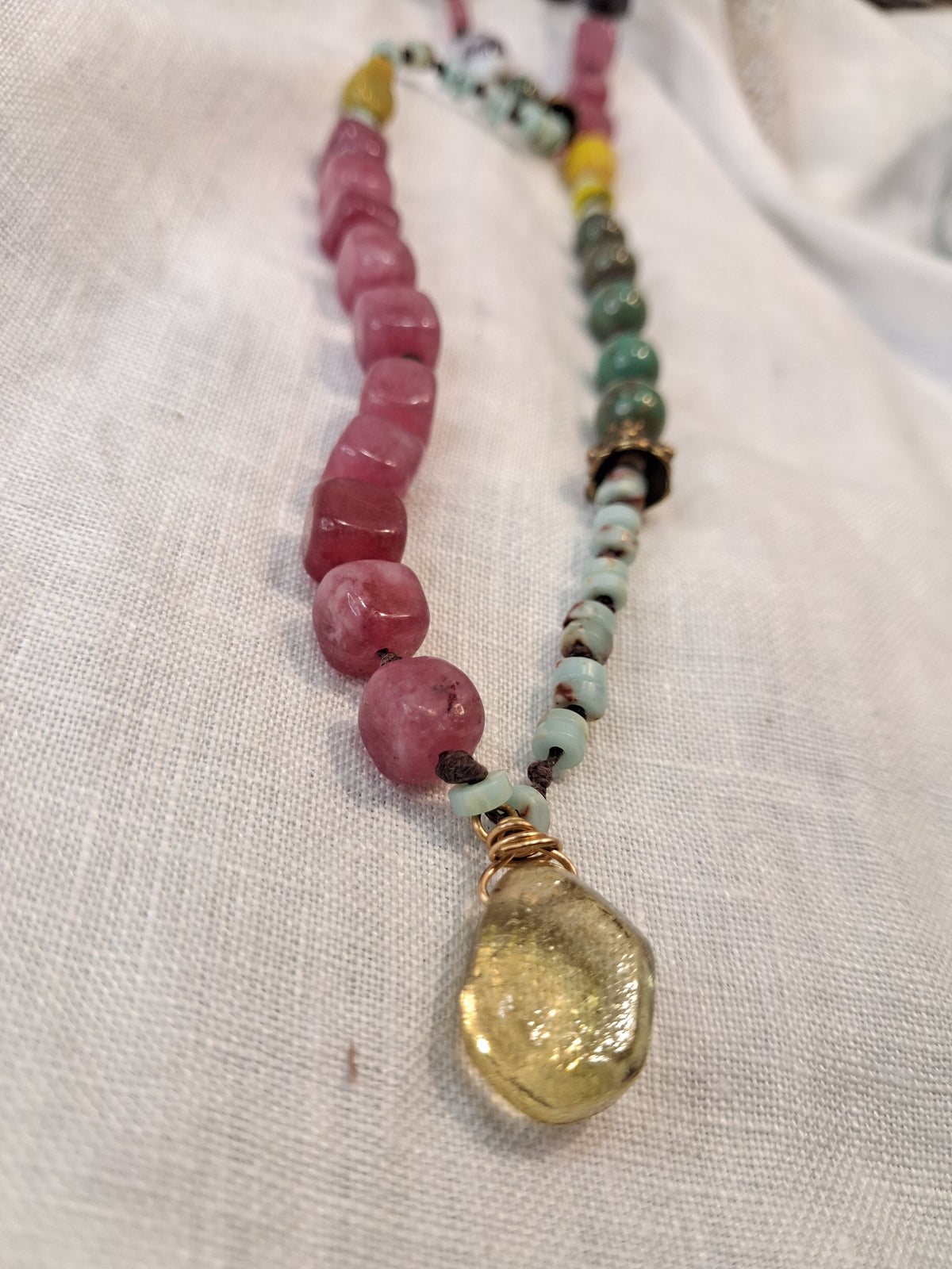 Pink and green stone beaded necklace featuring a yellow glass pendant on cord, handmade by Melly