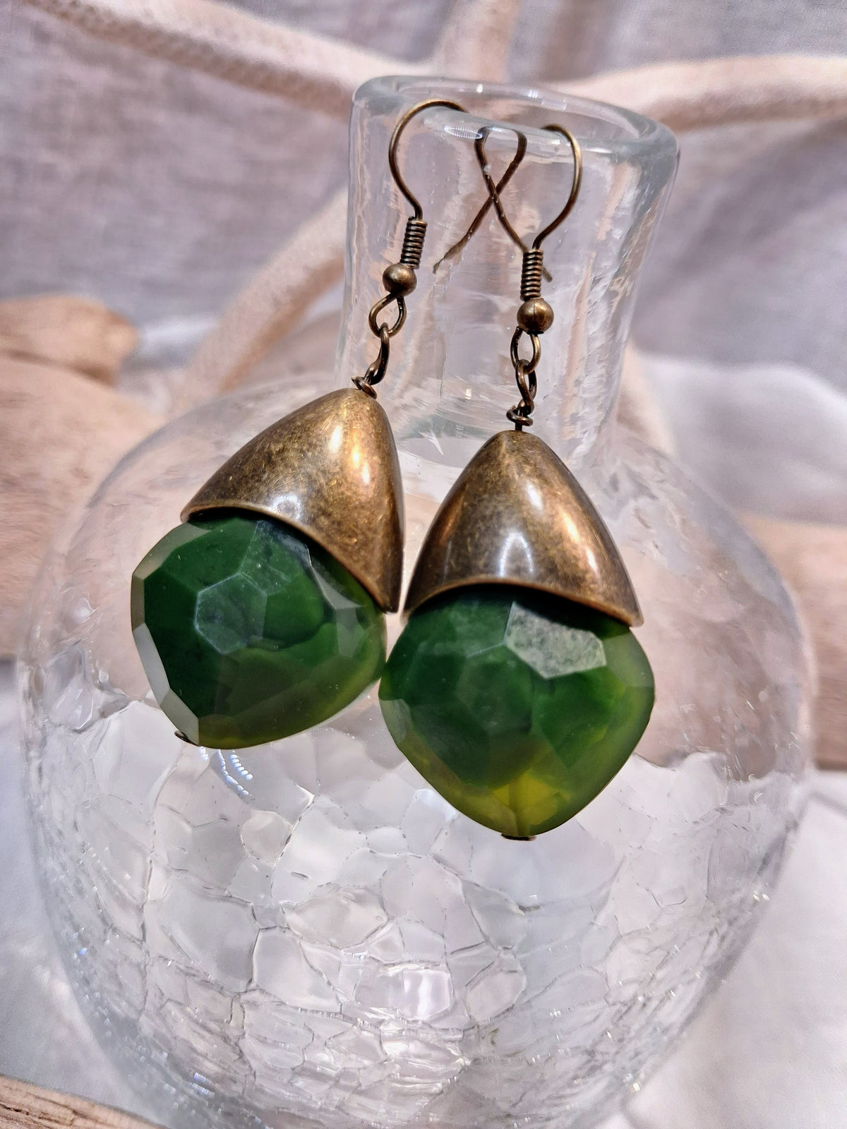 Emerald green bishop dangle earrings with faceted stones and bronze metal caps, handmade by Melly
