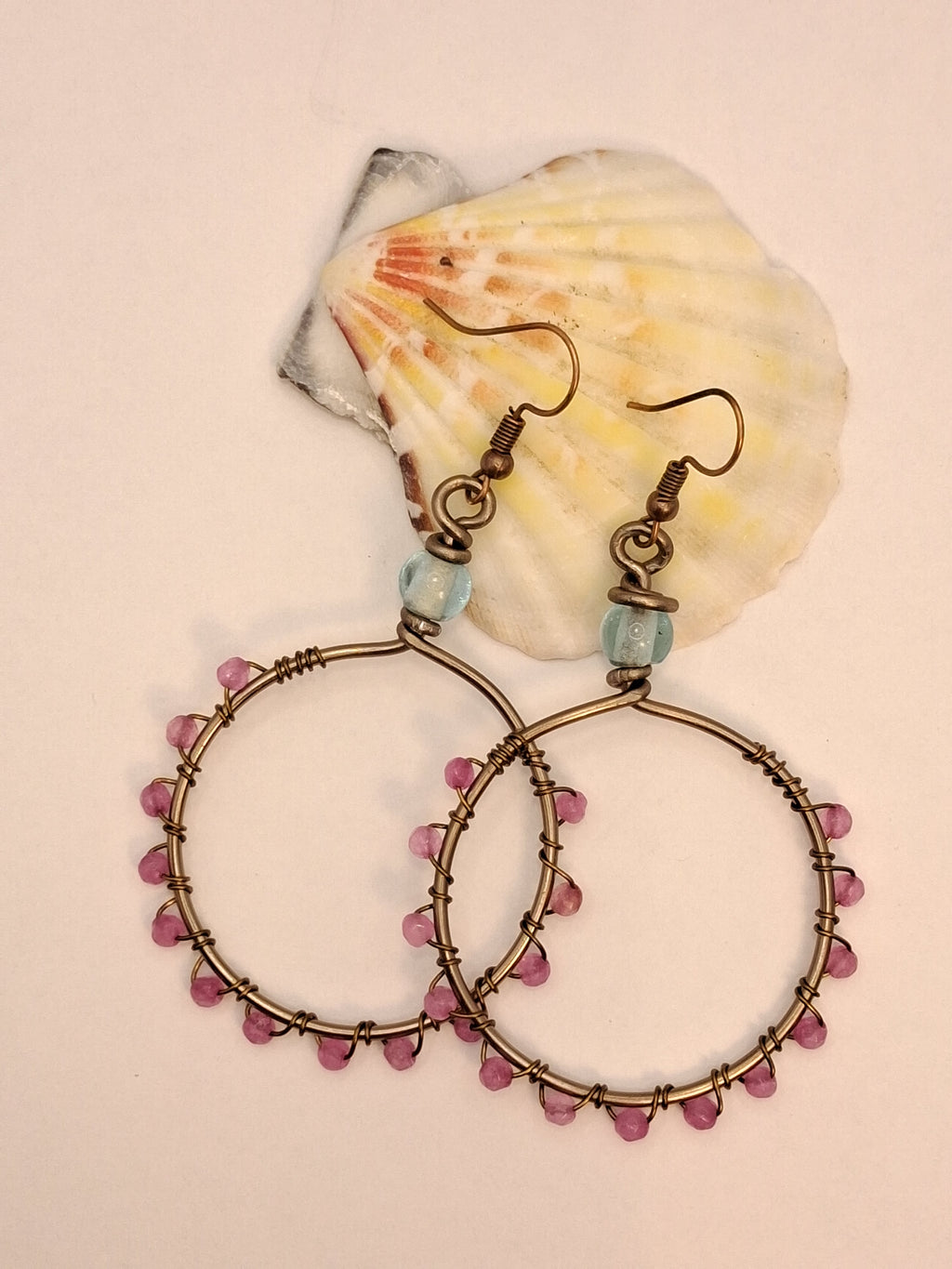 Light blue and pink jade wire wrapped hoop earrings with beaded details, handmade by Melly
