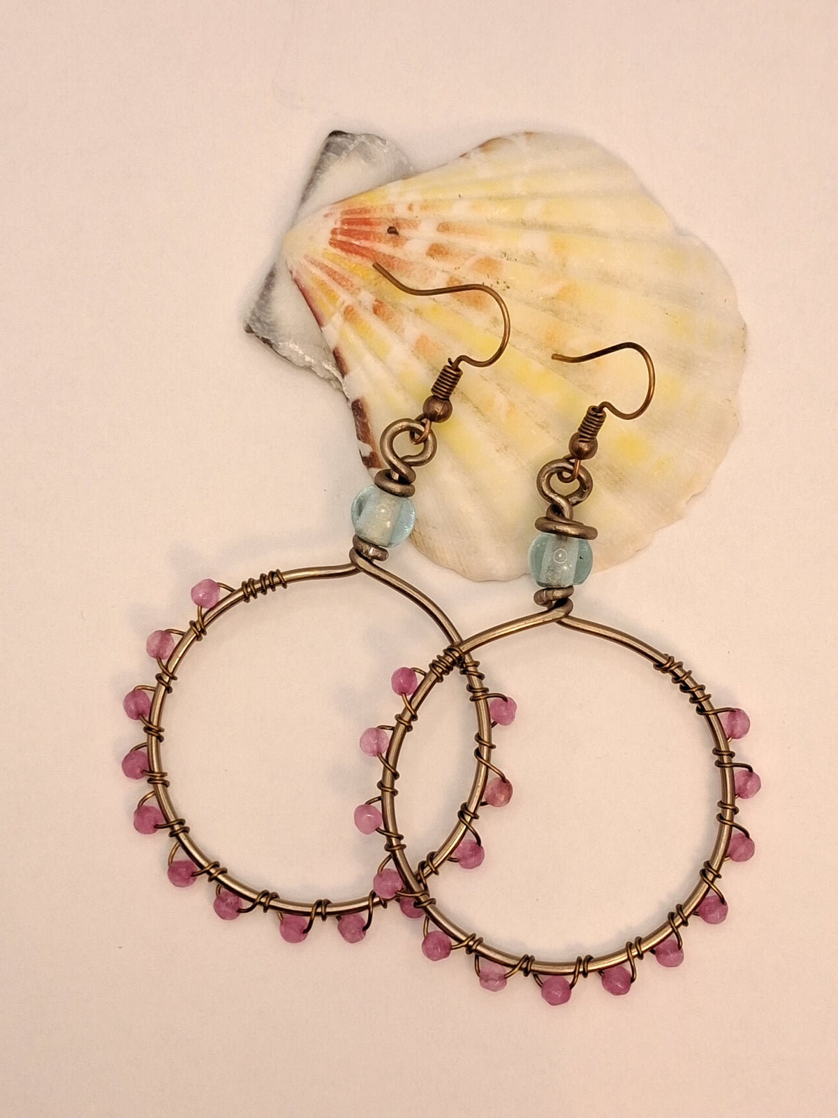 Light blue and pink jade wire wrapped hoop earrings with beaded details, handmade by Melly