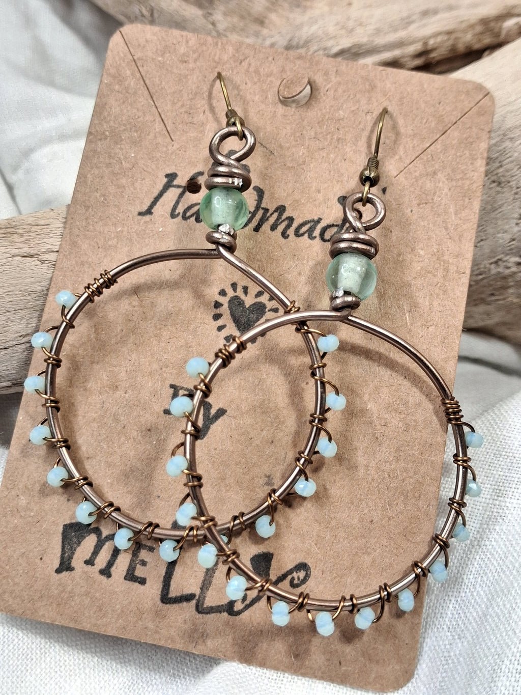 Light blue and copper wire-wrapped hoop earrings handmade by Melly