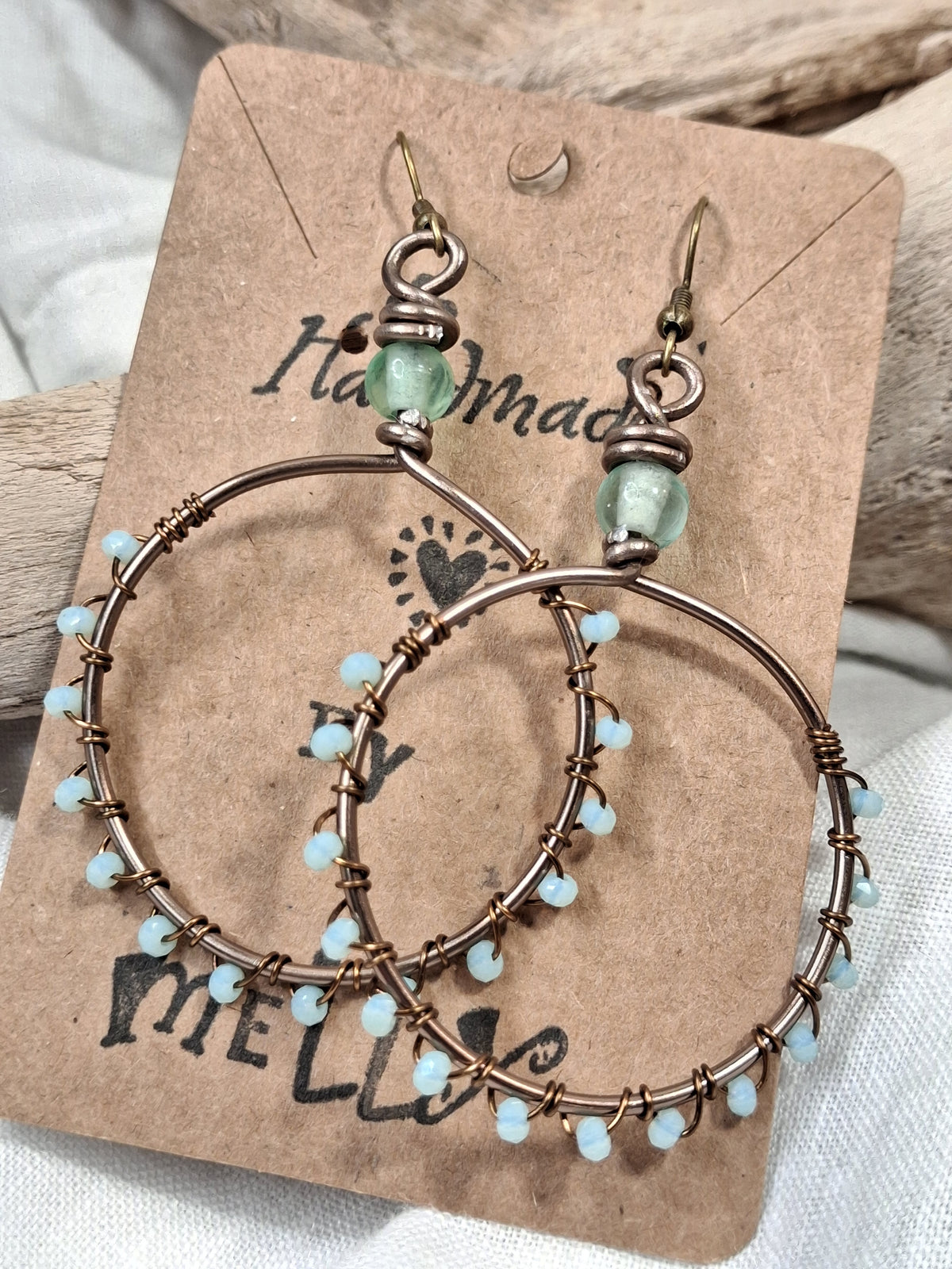 Light blue and copper wire-wrapped hoop earrings handmade by Melly
