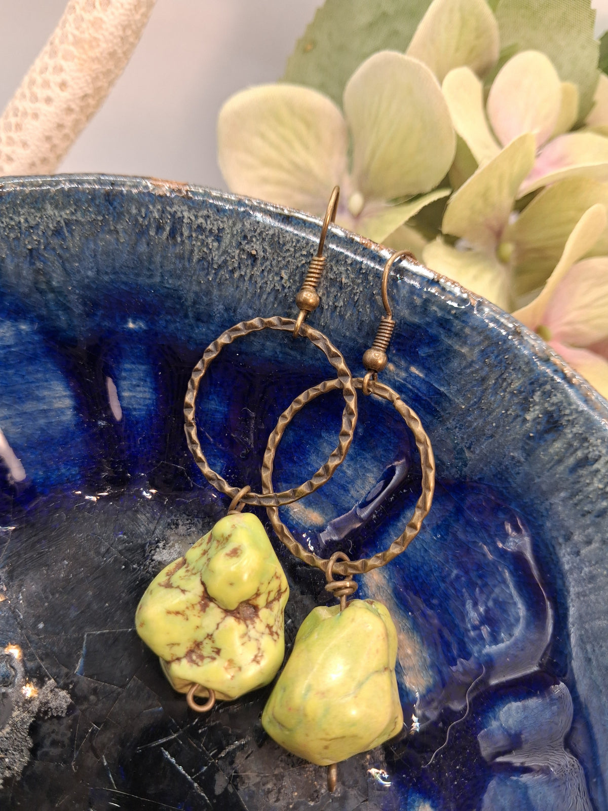Lime green nugget stone drop earrings hanging from textured bronze hoops, handmade by Melly