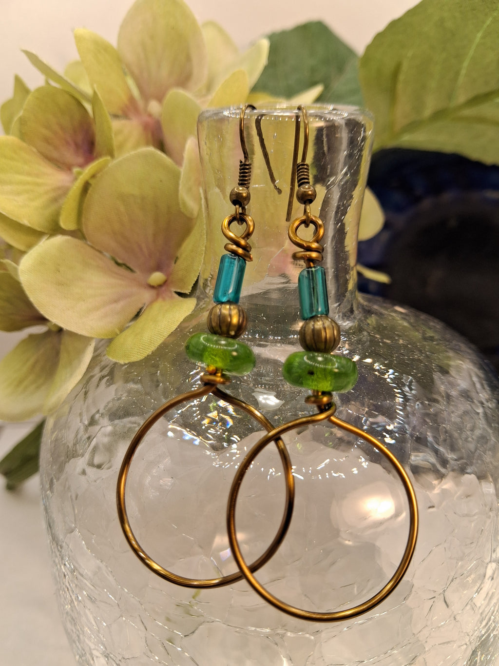 Teal and emerald green hard candy dangle earrings featuring glass beads on bronze wire, handmade by Melly