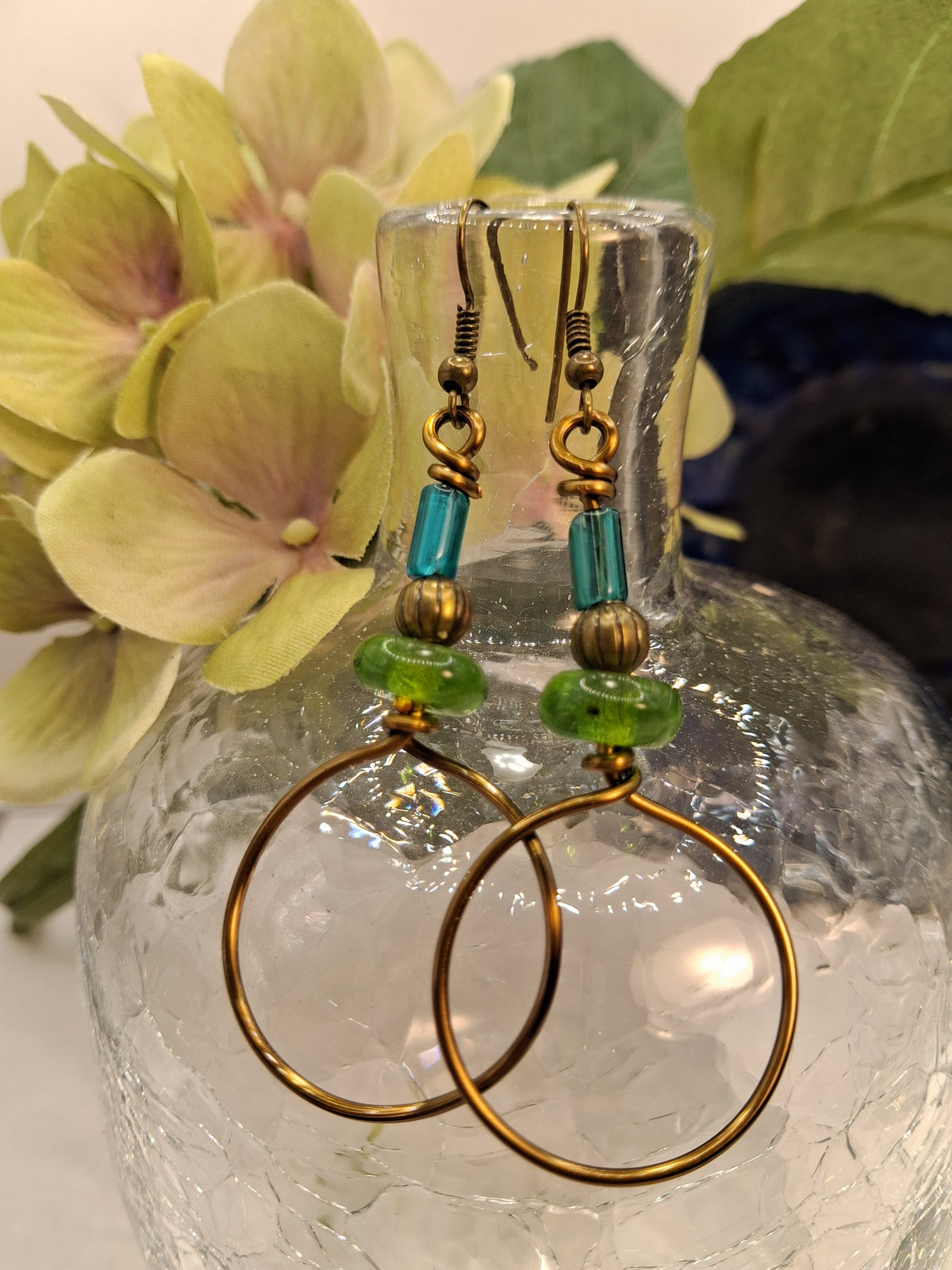 Teal and emerald green hard candy dangle earrings featuring glass beads on bronze wire, handmade by Melly