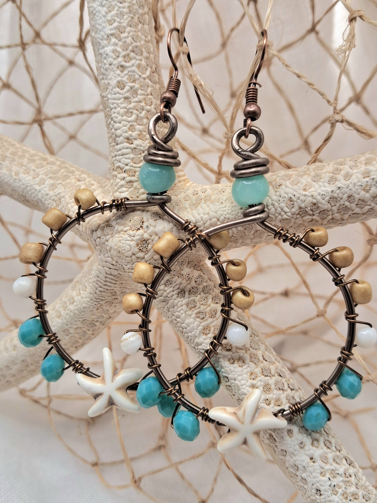 Turquoise and maple wire wrapped starfish hoop earrings with beaded accents, handmade by Melly