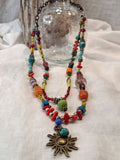 Turquoise, lime, and red beaded sunset necklace with brass sun pendant, handmade by Melly