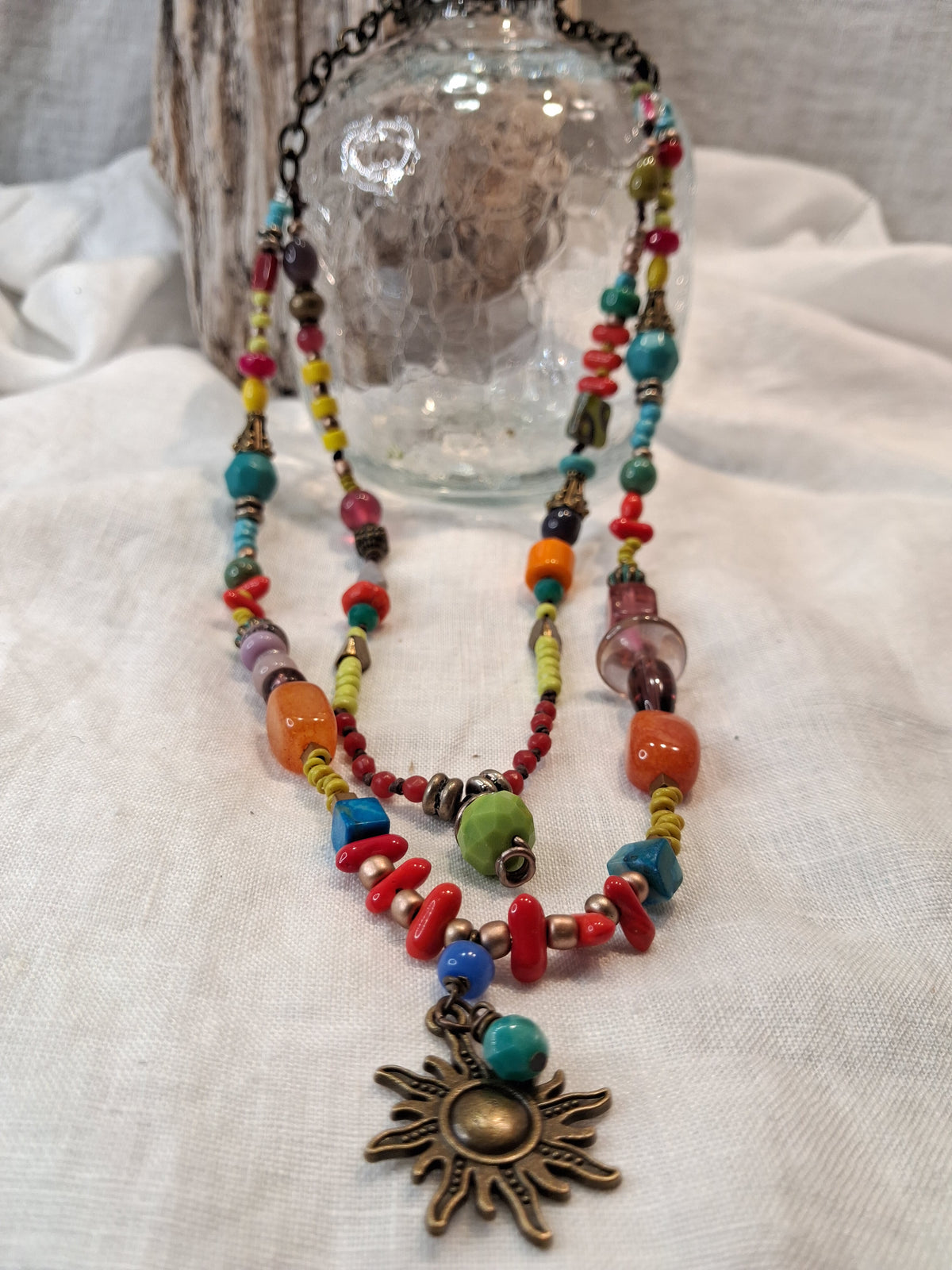 Turquoise, lime, and red beaded sunset necklace with brass sun pendant, handmade by Melly