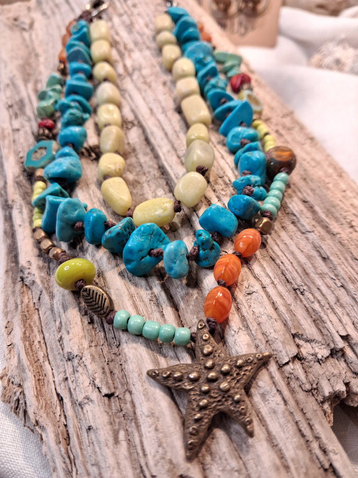 Turquoise, teal, and lime beaded necklace featuring a bronze starfish pendant, handmade by Melly