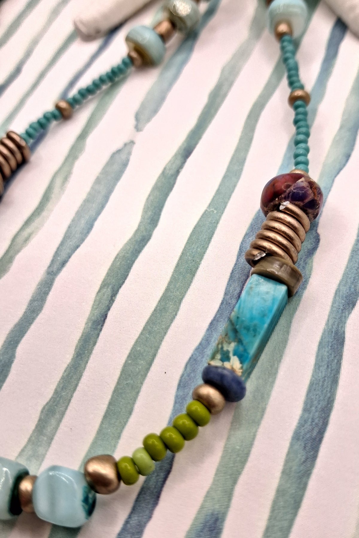 Turquoise beaded necklace featuring mixed stone beads and metallic accents, handmade by Melly.