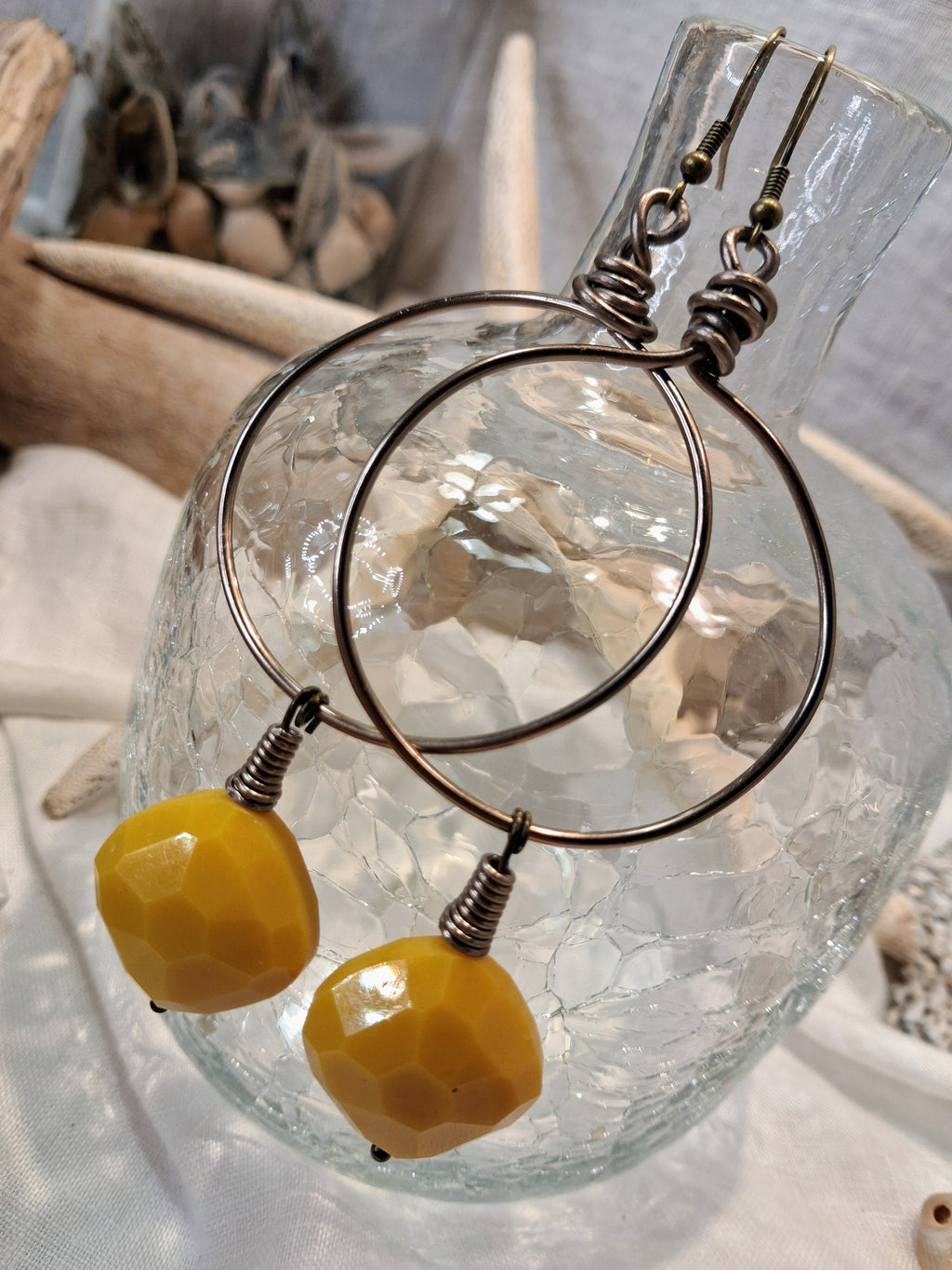 Yellow wire wrapped hoop earrings featuring faceted beads and metal hardware, handmade by Melly